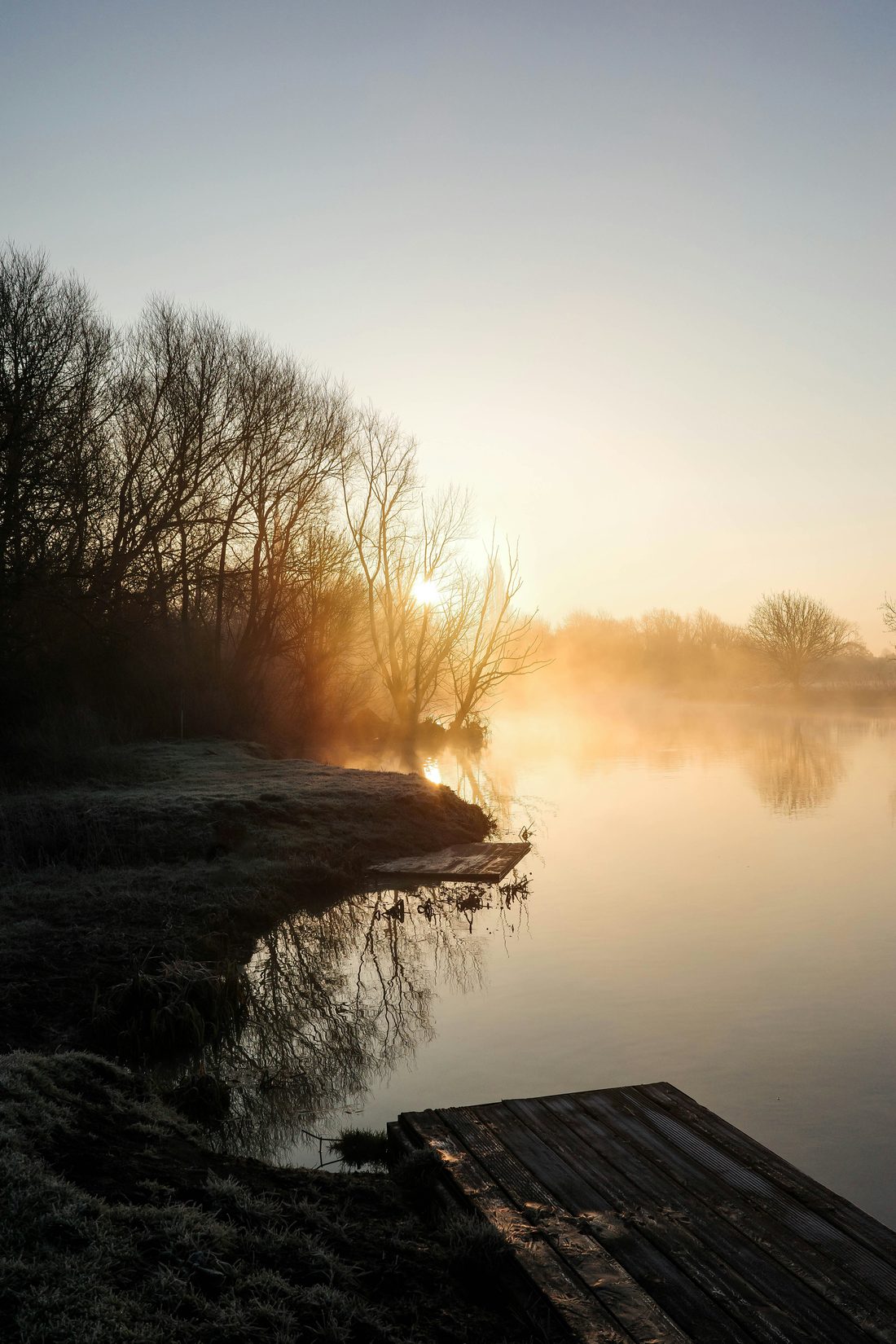 Rivière au lever du jour, brume dorée sur l'eau